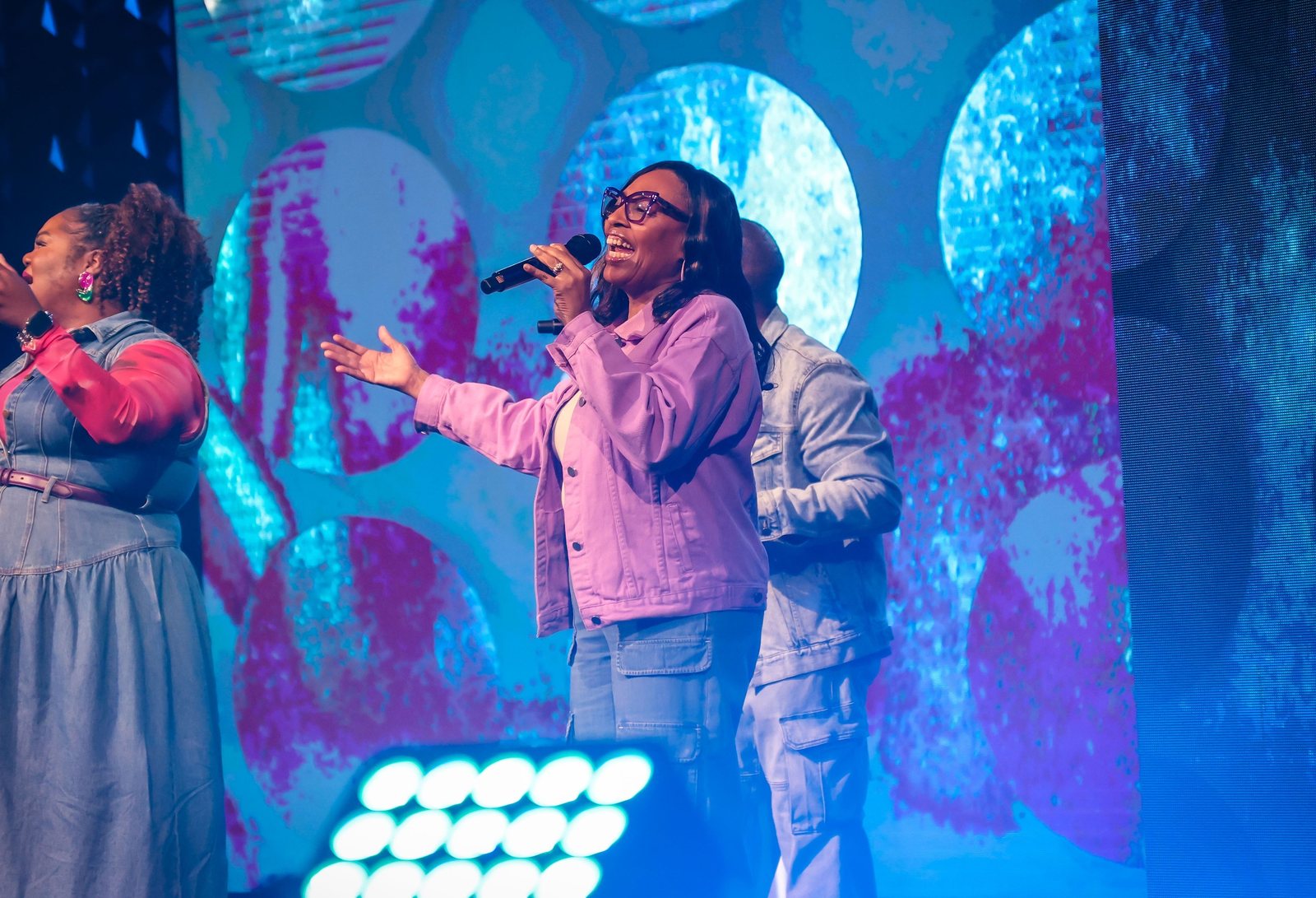 Worship leader singing under blue lights